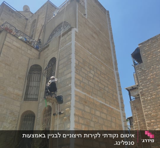 אדם מטפס על קיר אבן עם ציוד איטום